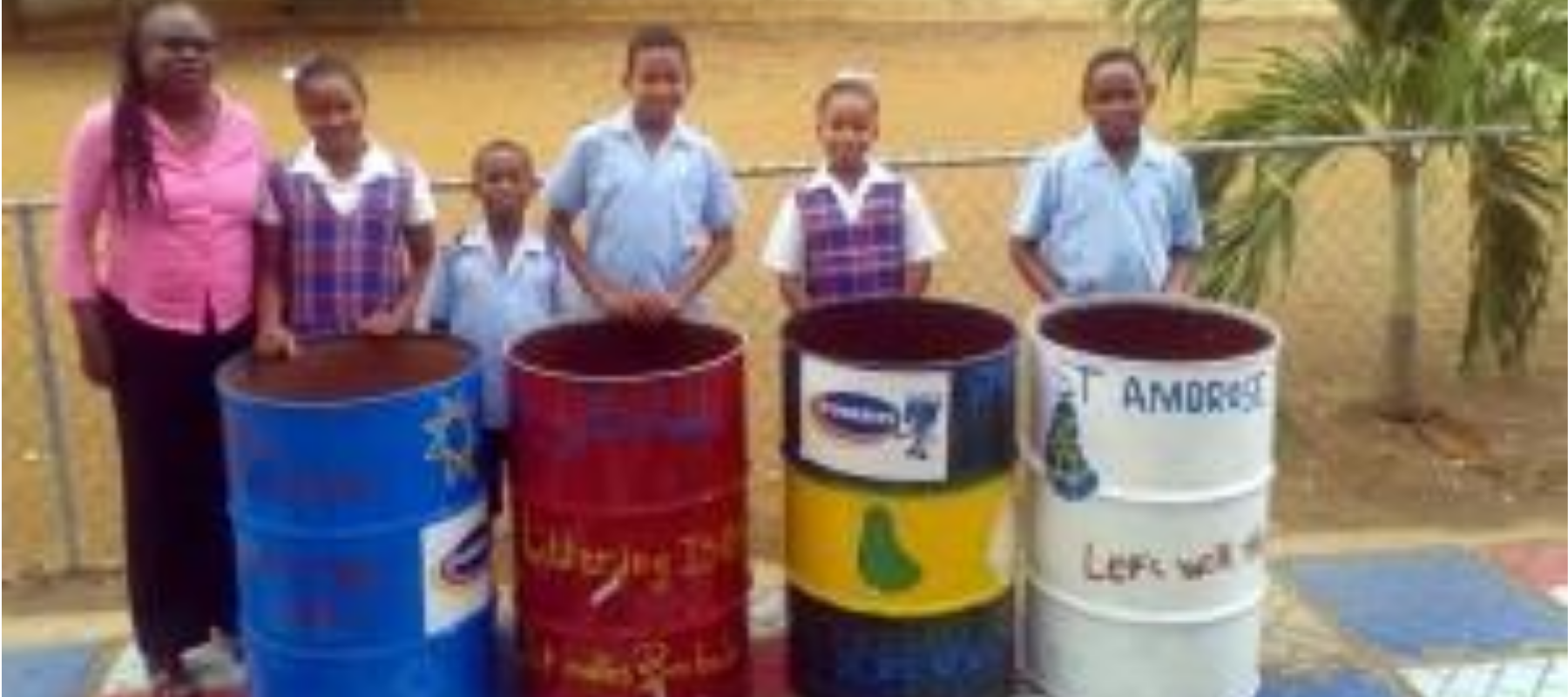 Principal Jacqueline Andewele of St Ambrose Primary with some of the cans painted by the students.