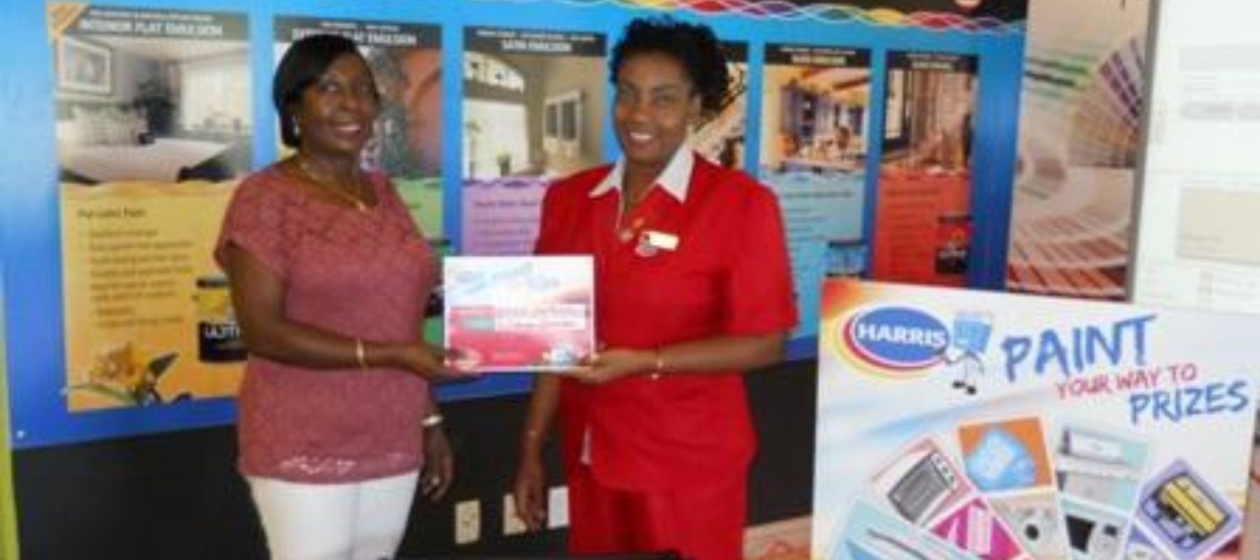 Harris' Suzanne Yarde presenting Sherron Stephens (right) with her Weber grill First-time homeowner Sherron Stephens has another reason to celebrate, as she is one of the lucky winners in this year's Harris Paints " Prizes for 40 Years" Christmas promotio