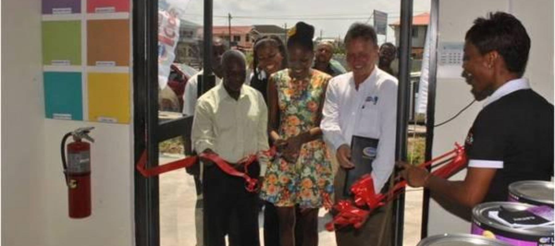 Minister within the Ministry of Communities Keith Scott (left) and Harris Paints CEO Ian Kenyon (second, right) react as Diamond resident Alyssa Griffith cuts the ribbon to declare the facility open
