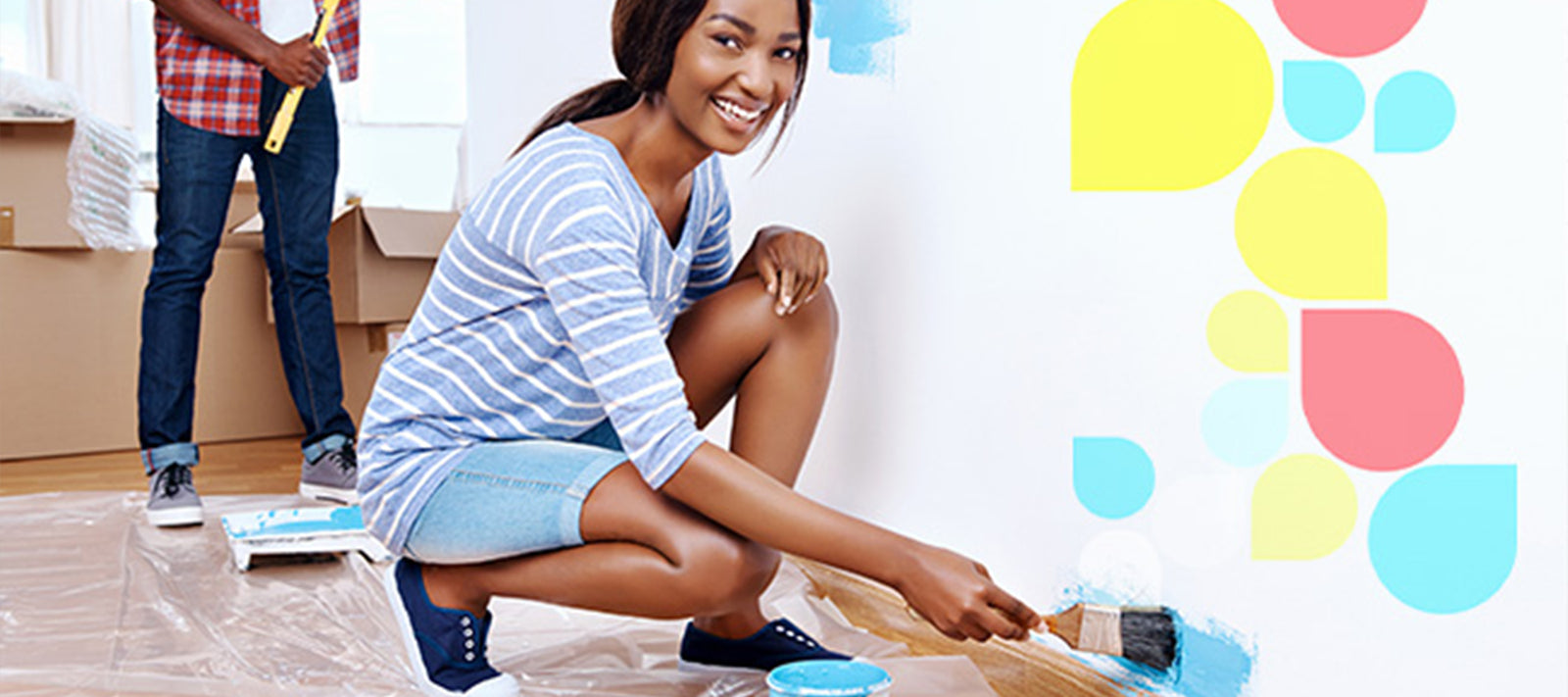 A woman painting on a wall in a house.