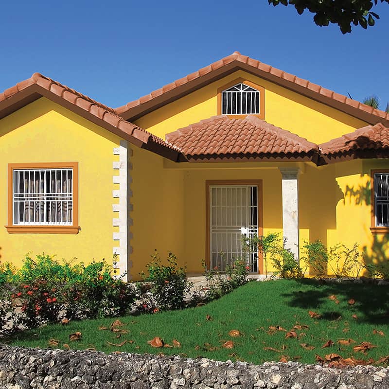 Exterior of a house in the Caribbean, painted bright yellow.