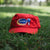 red hat with Harris Paints logo displayed in the grass